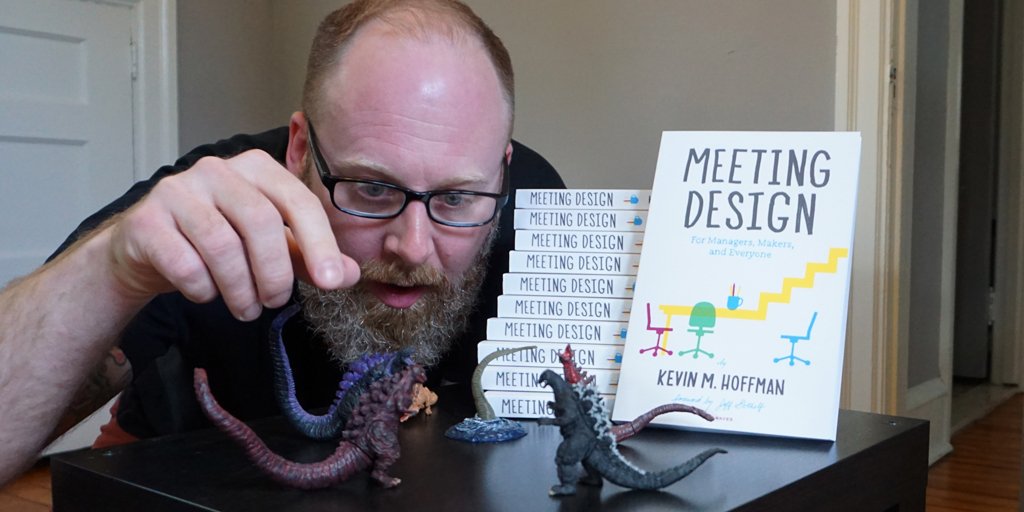 Kevin M. Hoffmann playing with toys in front of his book, Meeting Design.
